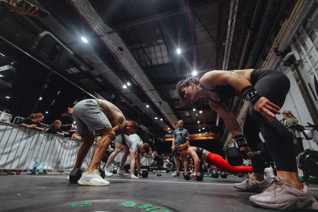 Athletinnen und Athleten stützen sich nach dem Workout erschöpft auf die Knie